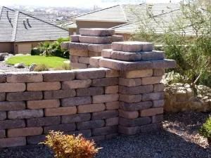 A brick wall with pillars in front of a house.