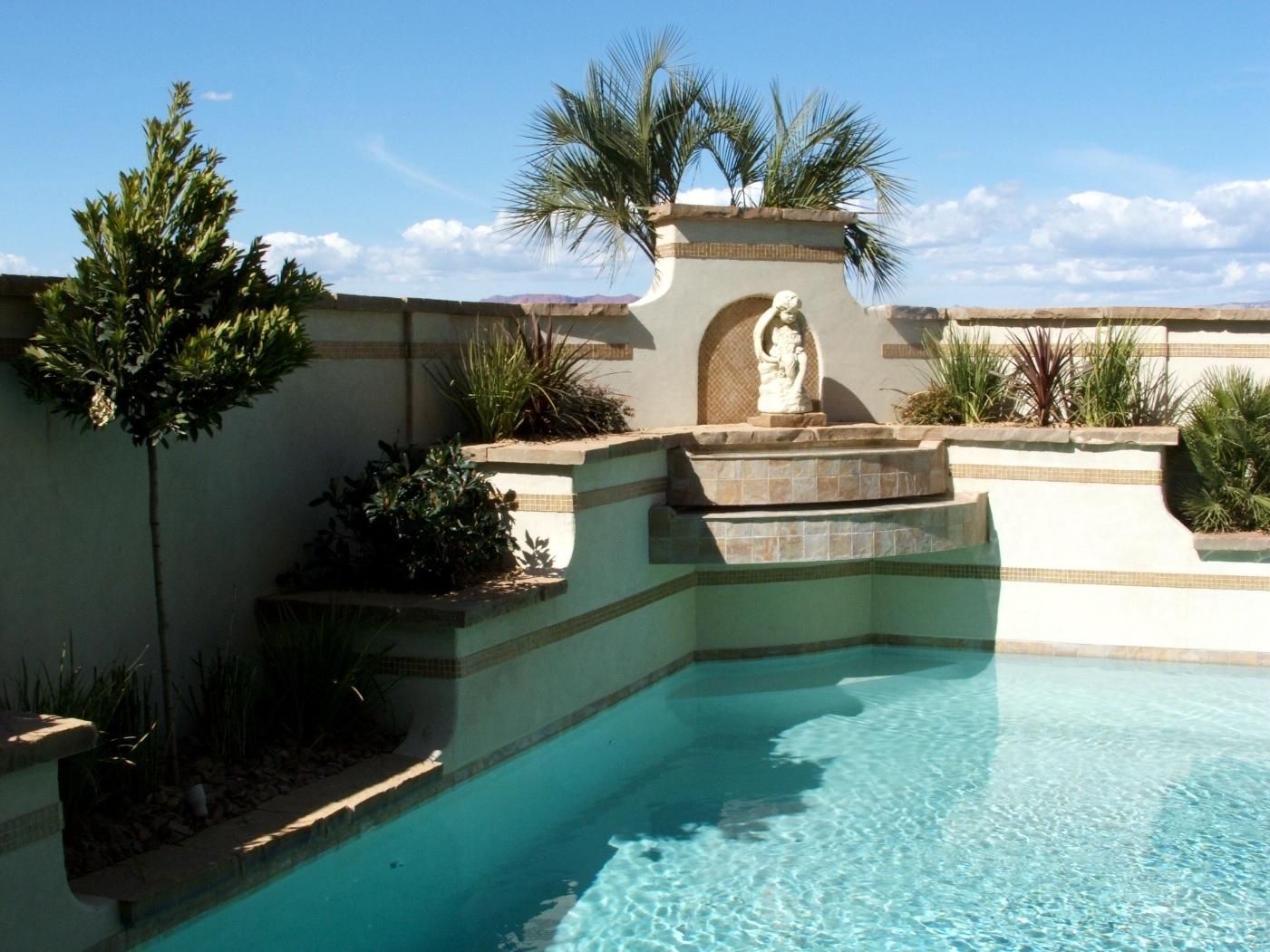 A swimming pool with a fountain in the middle of it