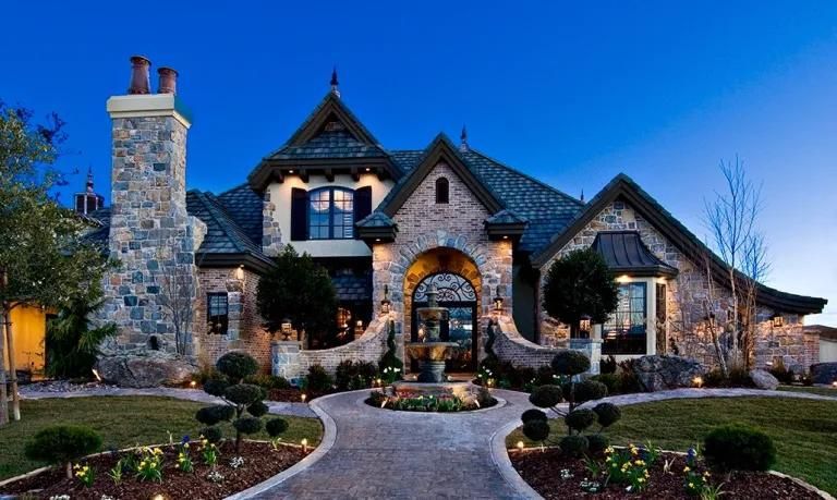 A large stone house with a blue sky in the background