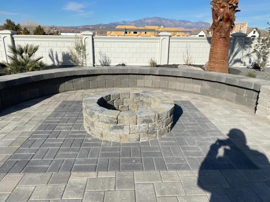 A fire pit is surrounded by bricks on a patio.