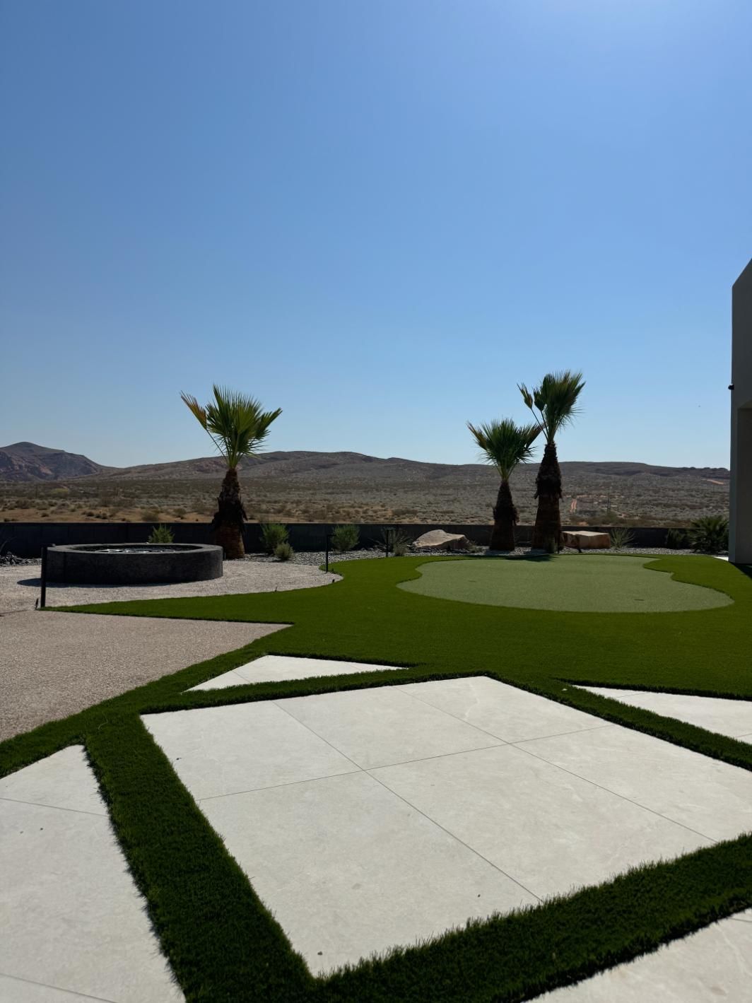 A lawn with a putting green and palm trees