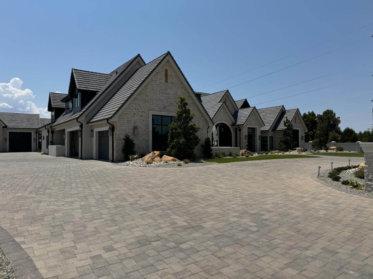 A large brick house with a large driveway in front of it.