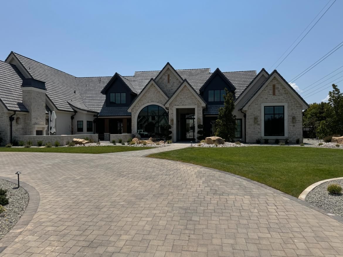 A large house with a brick driveway leading to it