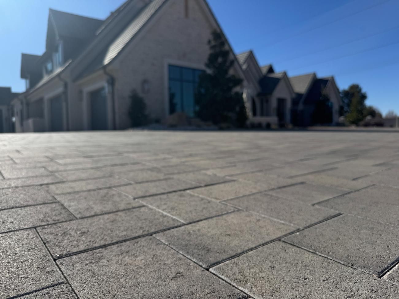 A large house is sitting on top of a brick driveway.