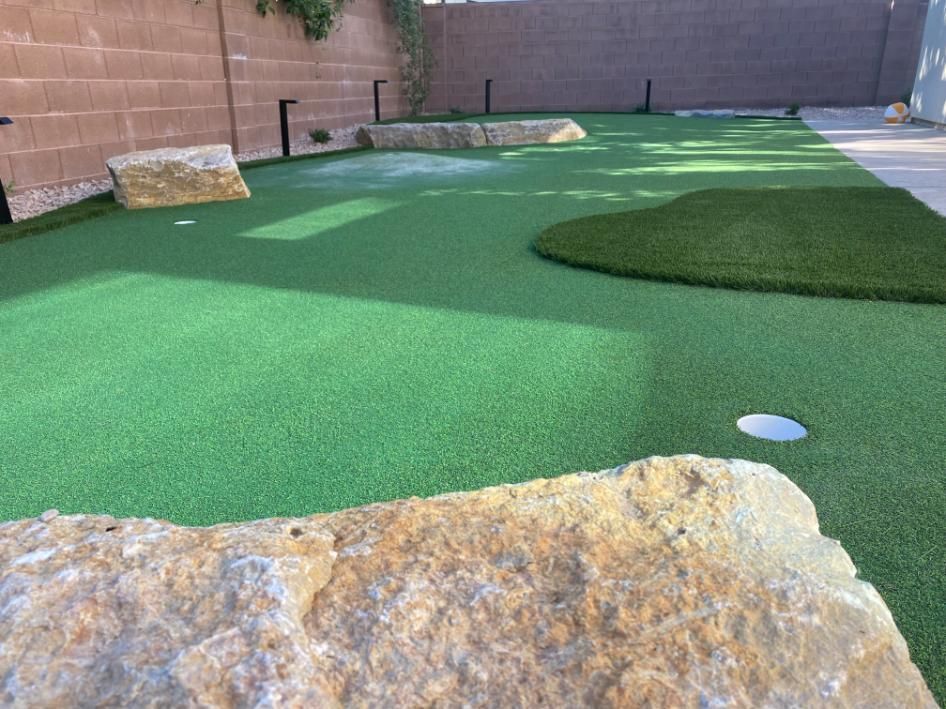 A golf course with a rock in the middle of it.