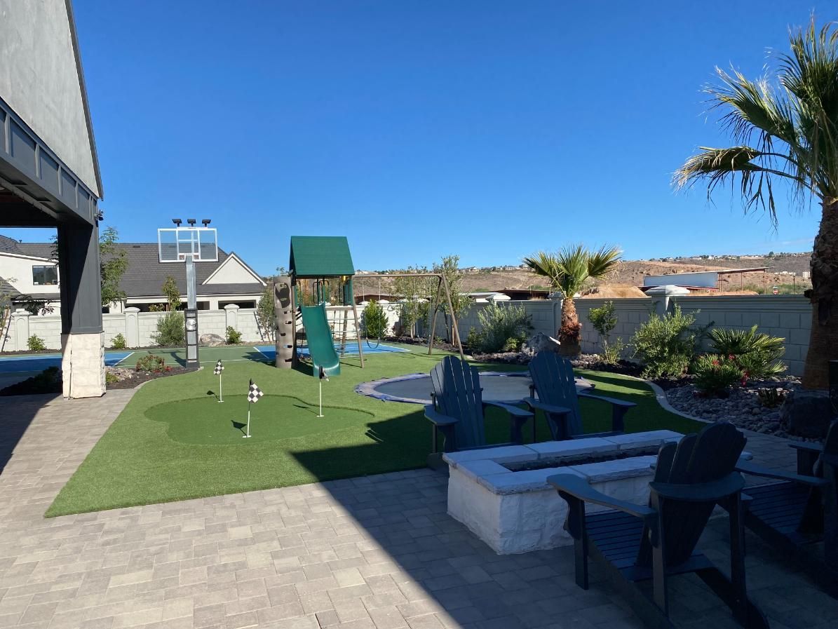 A backyard with a playground and a fire pit.