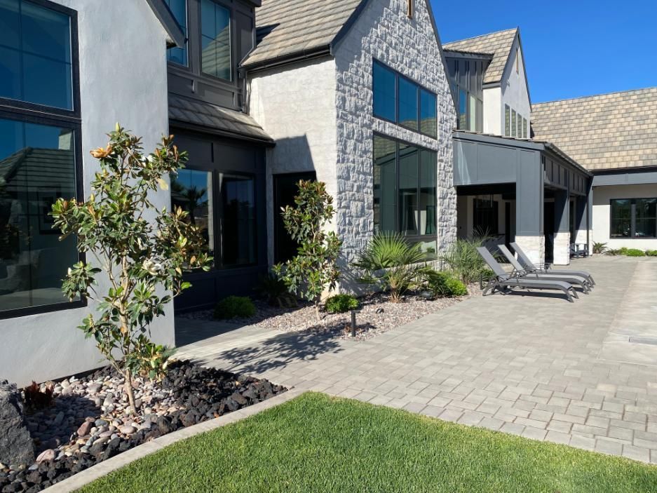 A large house with a patio and chairs in front of it.