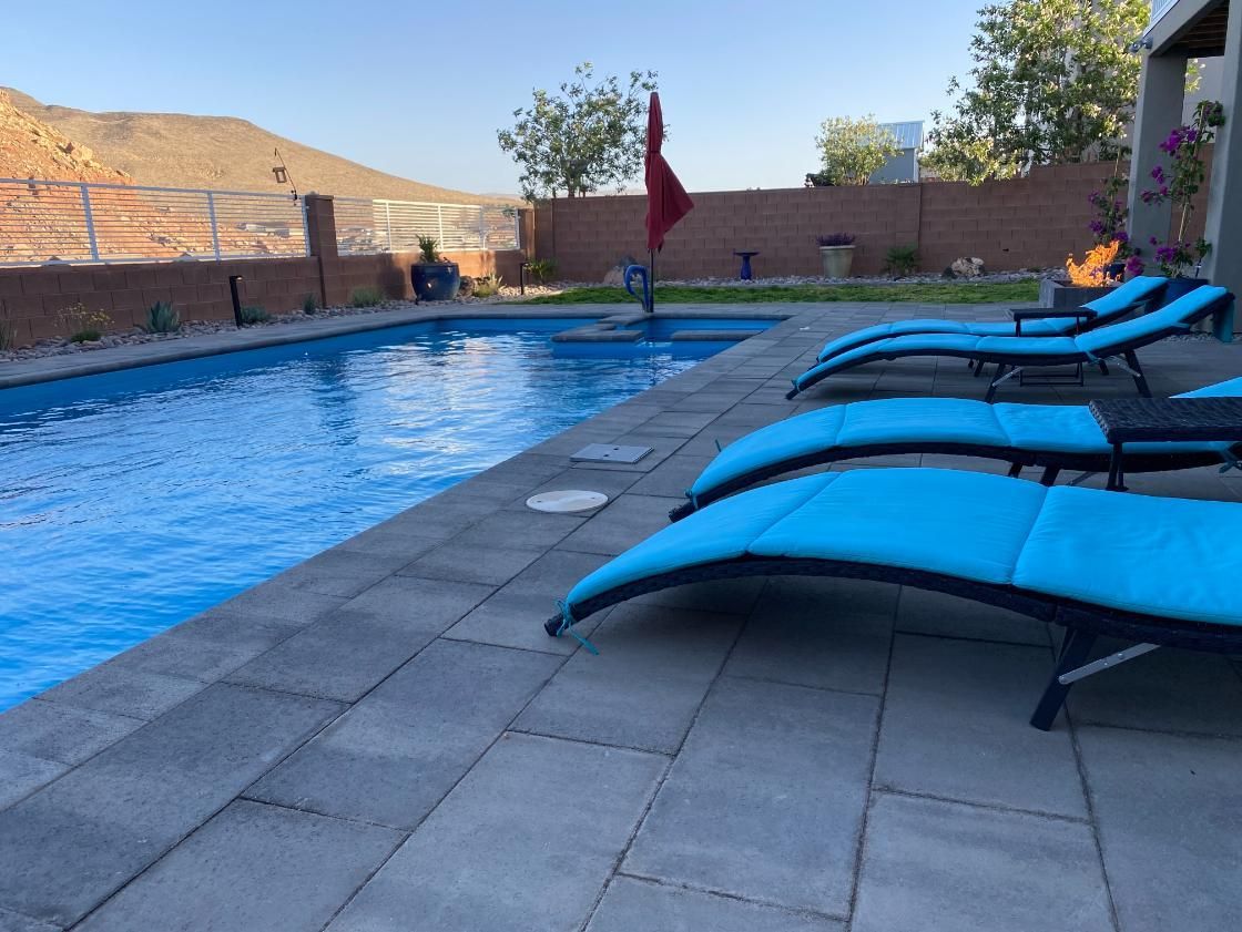 A row of blue lounge chairs sitting next to a swimming pool