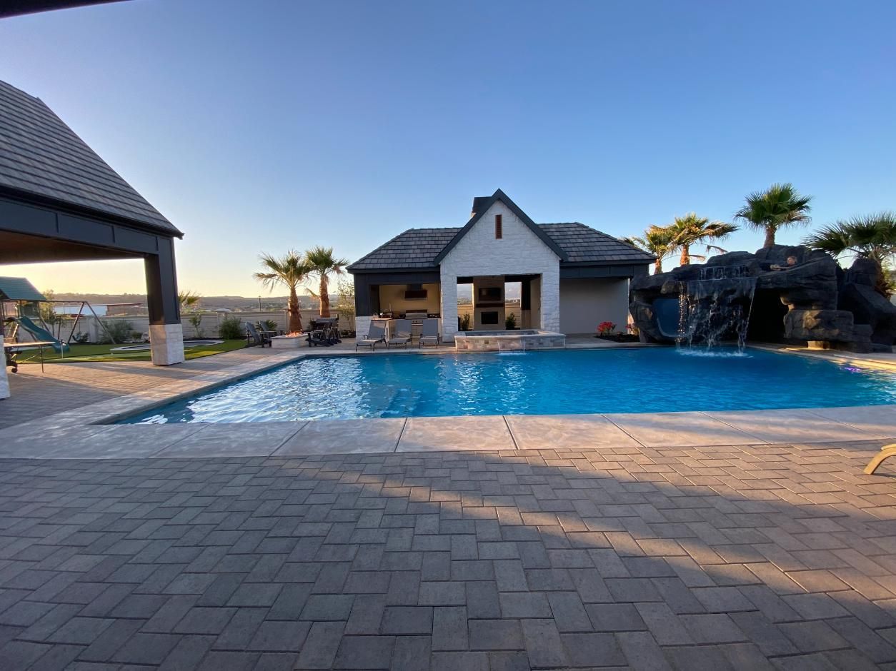 There is a large swimming pool in the backyard of a house.