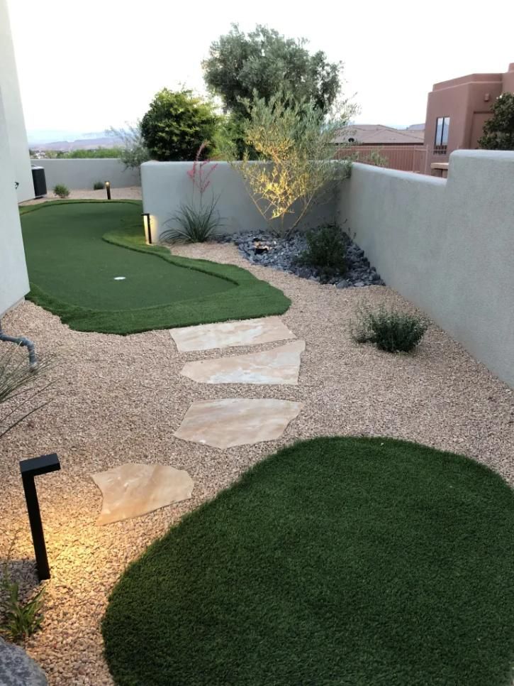 A garden with a putting green and a stone walkway.