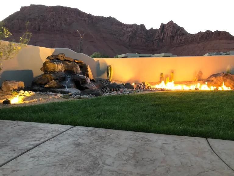 A fire pit in a backyard with mountains in the background