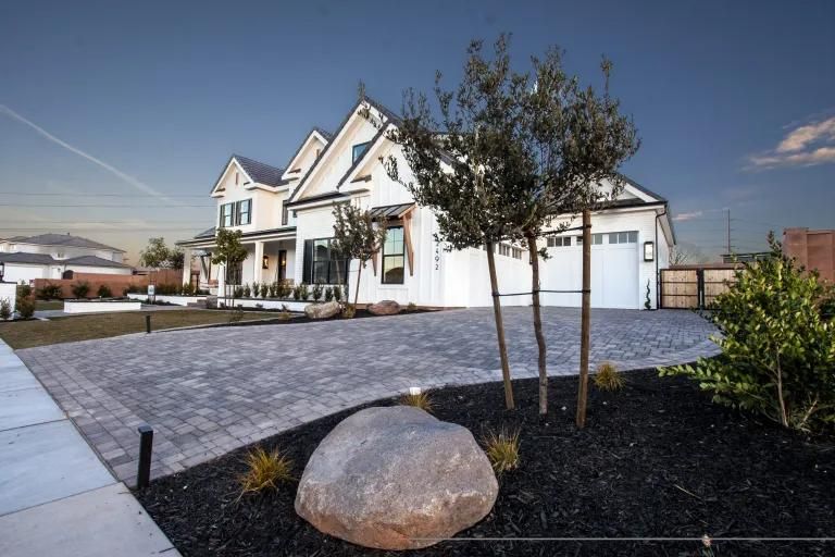A large white house with a large rock in front of it.