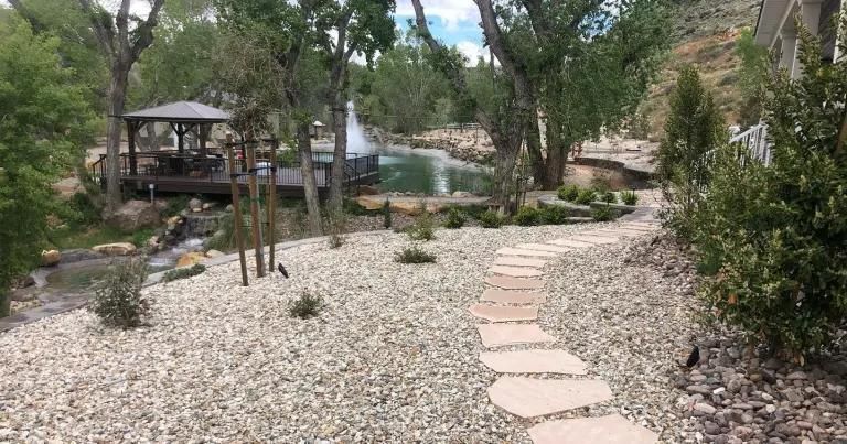 A stone path leading to a gazebo in the woods.