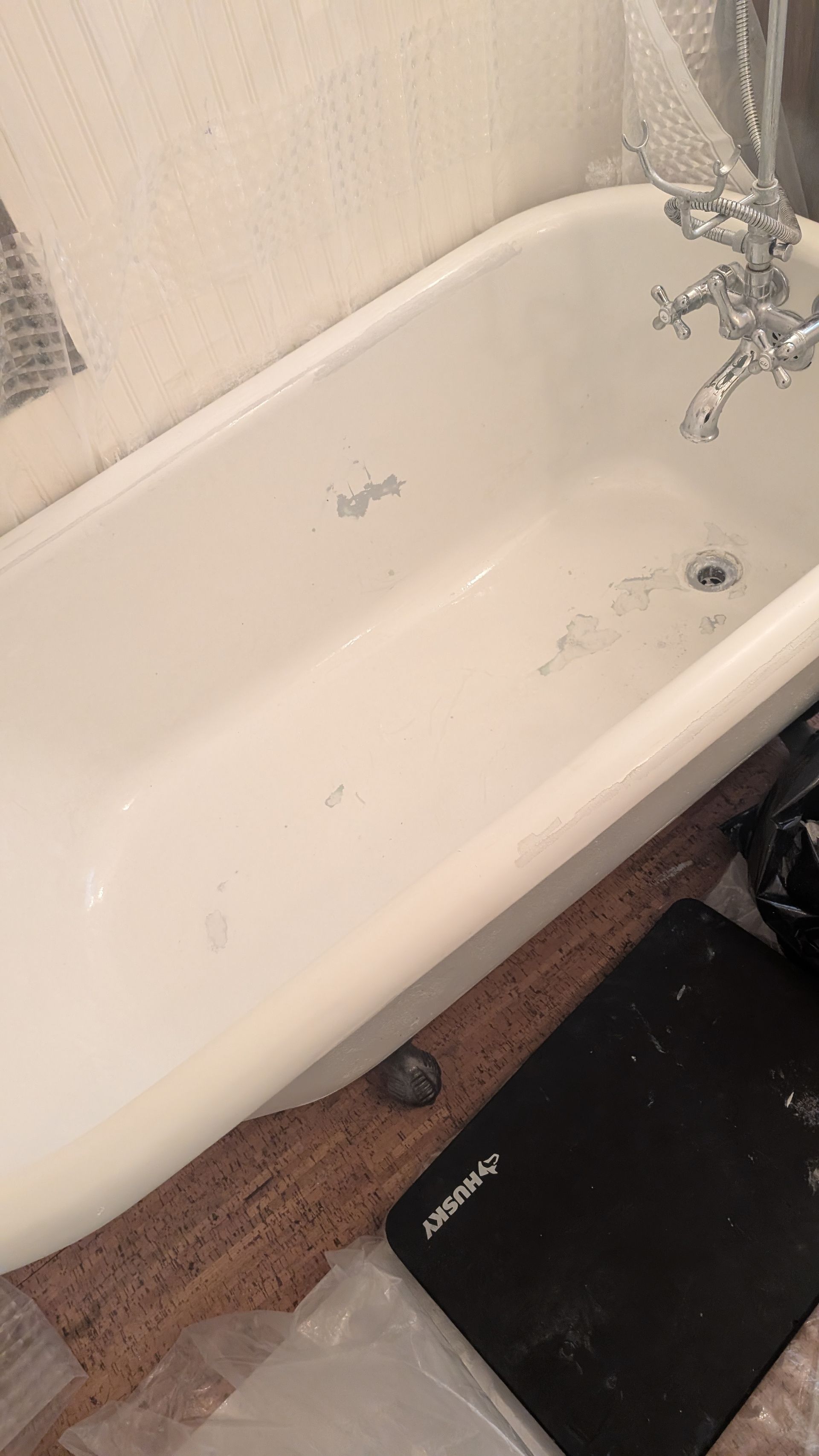 White bathtub with chrome fixtures, in a bathroom.