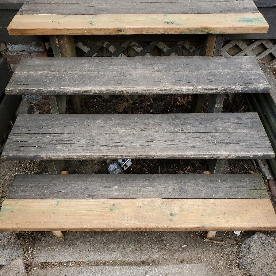 Wooden steps with weathered gray planks and lighter-colored edges.