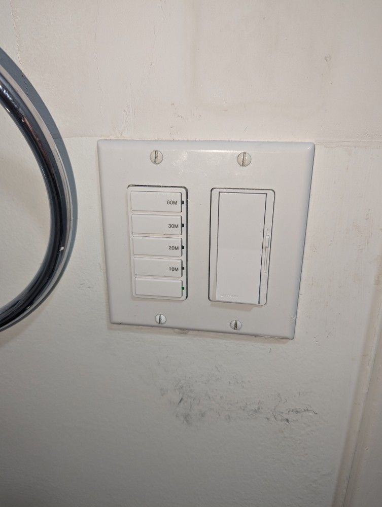 White light switch plate with five small switches and one large switch.