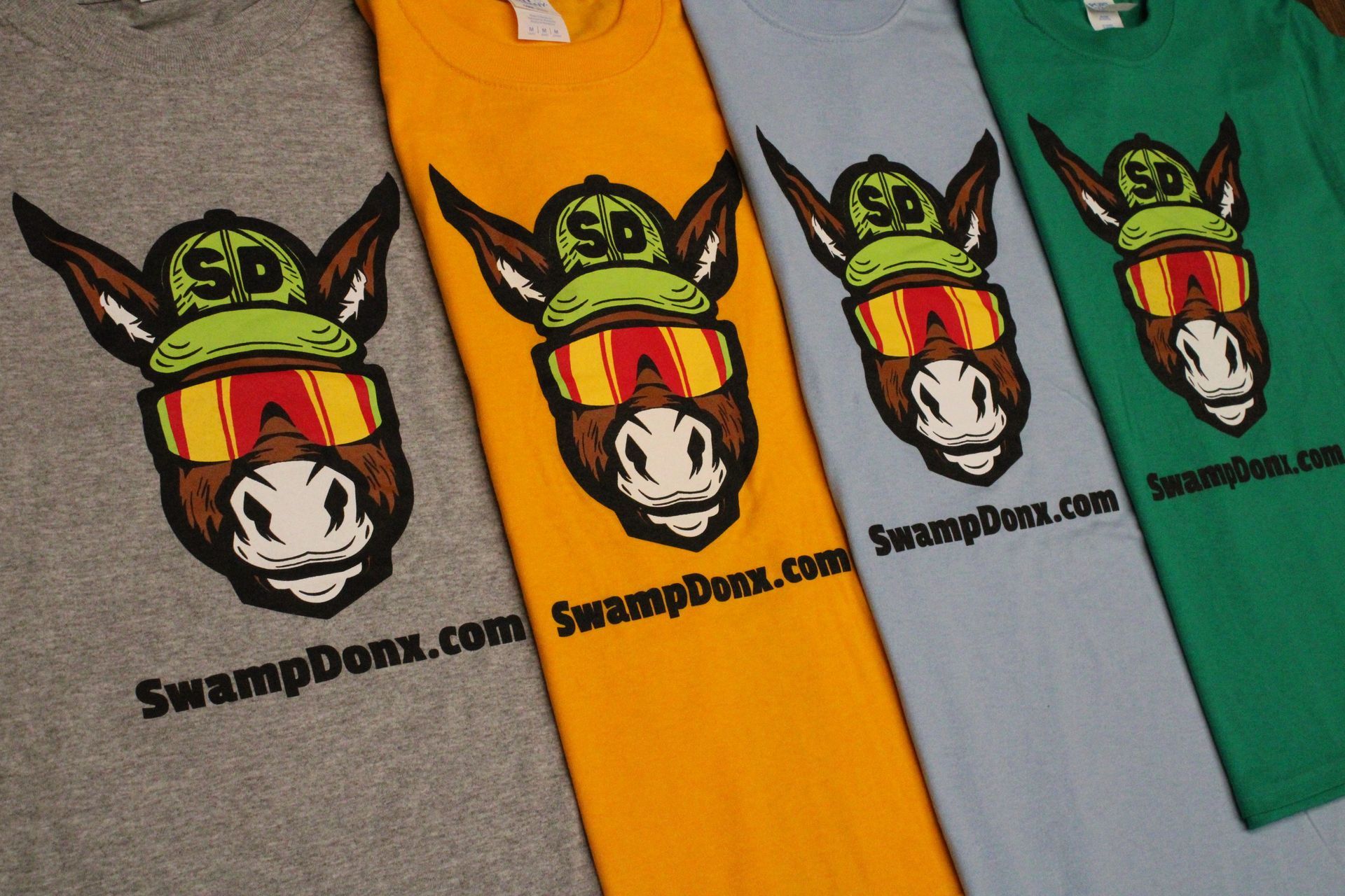 A bunch of shirts that say swamp donx.com on them