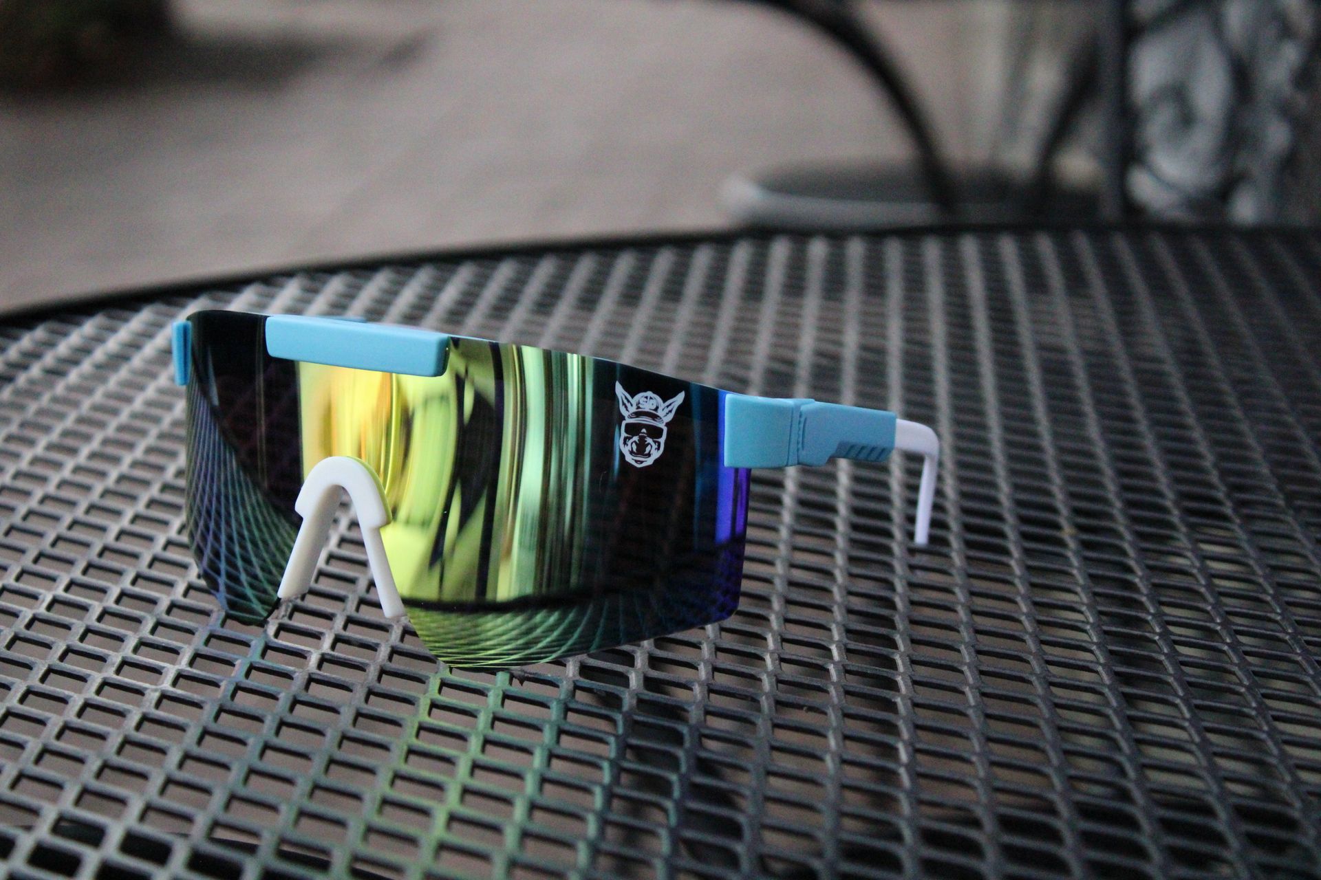 A pair of sunglasses is sitting on a metal table.