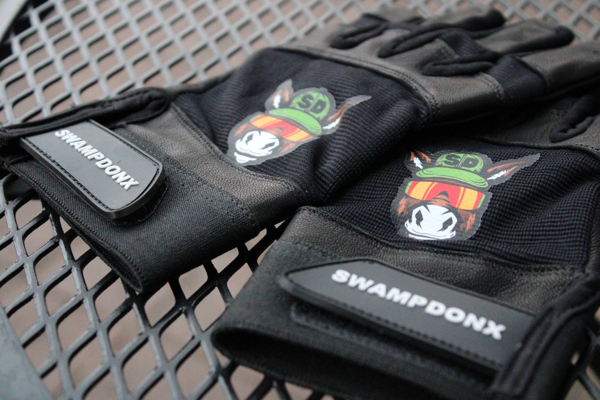 A pair of swampdonx gloves are sitting on a metal table