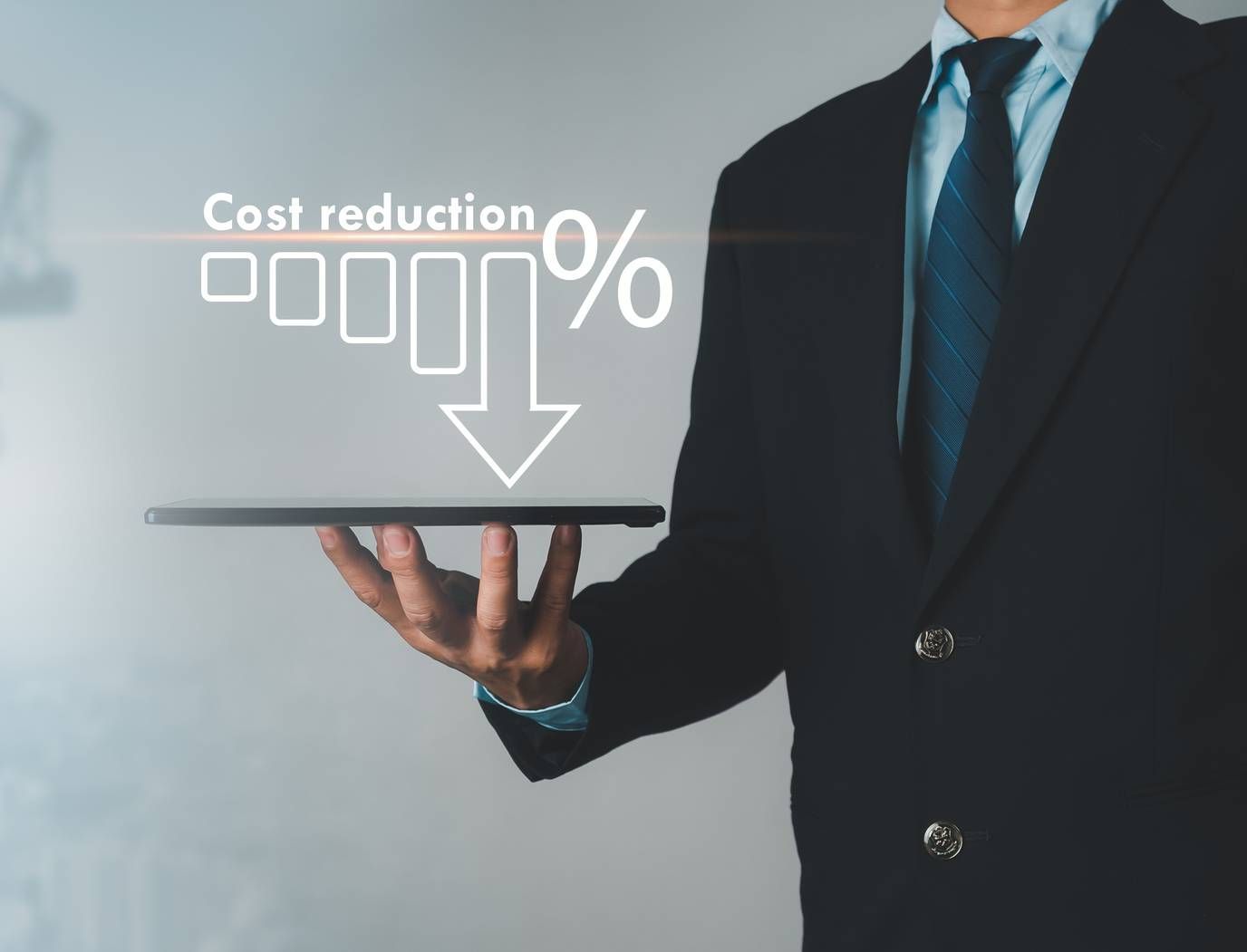 A man in a suit and tie is holding a tablet with the words cost reduction written on it.
