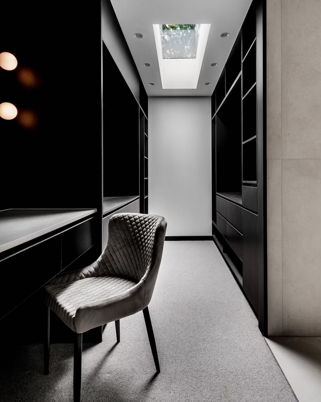 Dark walk-in closet with a desk, chair, shelves, and a skylight — Escarpment Building in Austinmer, NSW