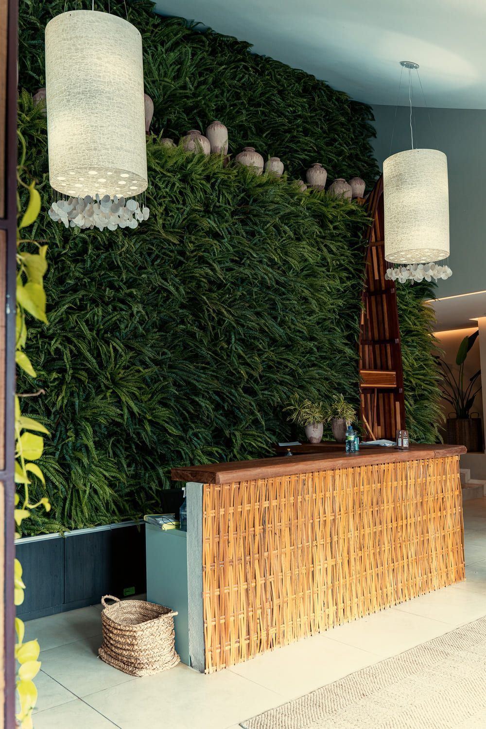 Uma área de recepção com um balcão de madeira e uma parede verde atrás dele.