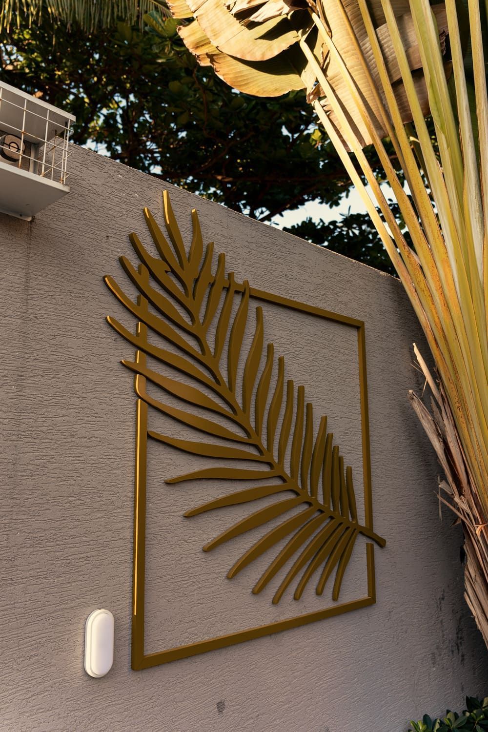 Uma folha de palmeira em uma moldura quadrada na parede