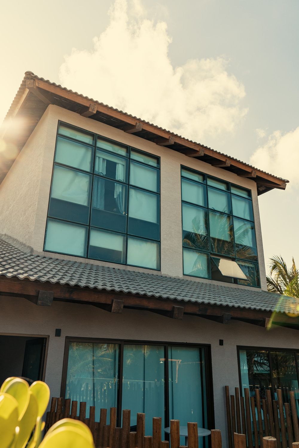 Uma casa grande com muitas janelas e uma cerca de madeira