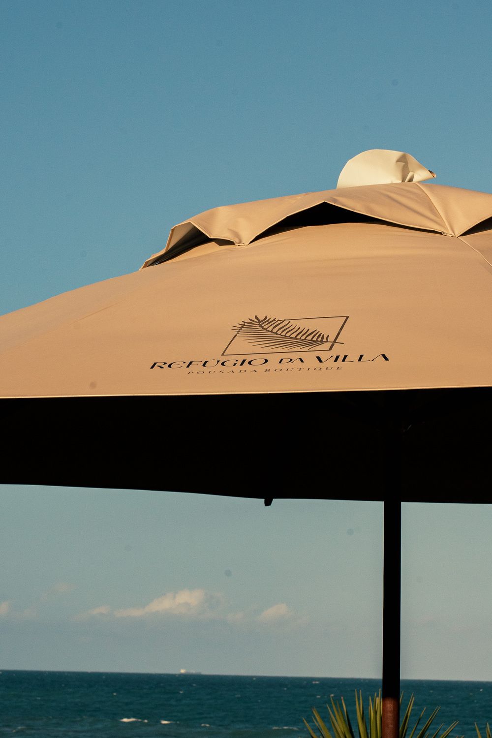 Um grande guarda-chuva bege com a palavra villas nele