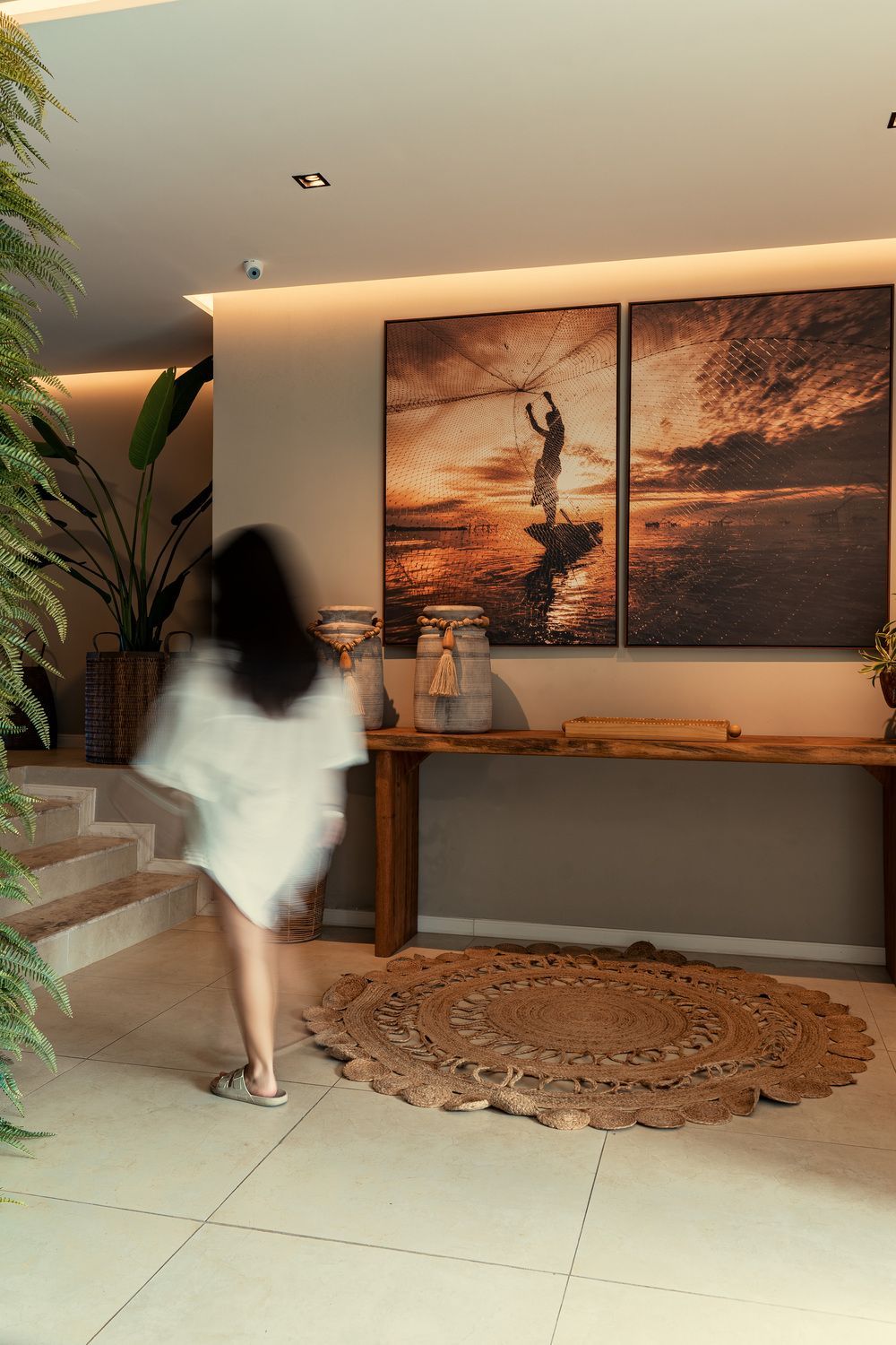 Uma mulher de vestido branco está caminhando por um corredor.