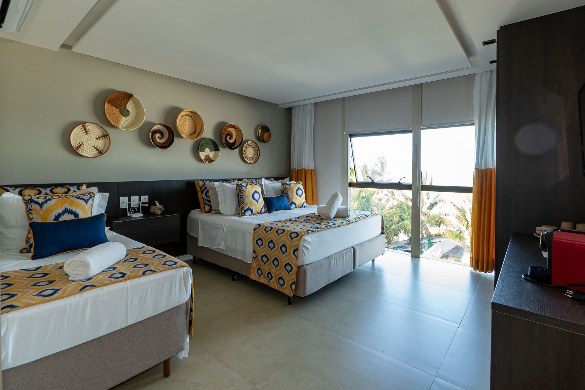 Um quarto de hotel com duas camas e uma janela grande.