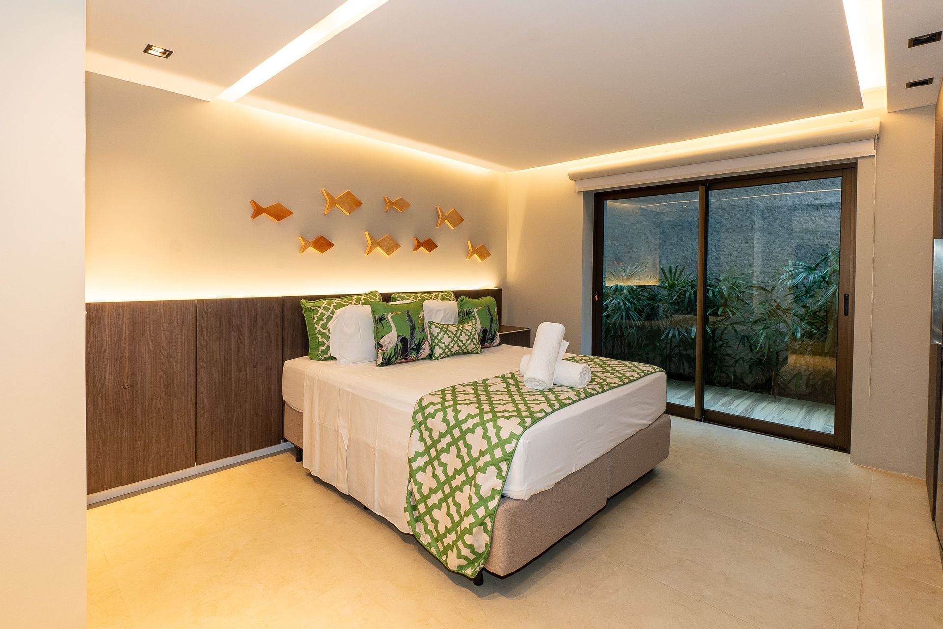 Um quarto de hotel com uma cama king size e uma porta de vidro deslizante.