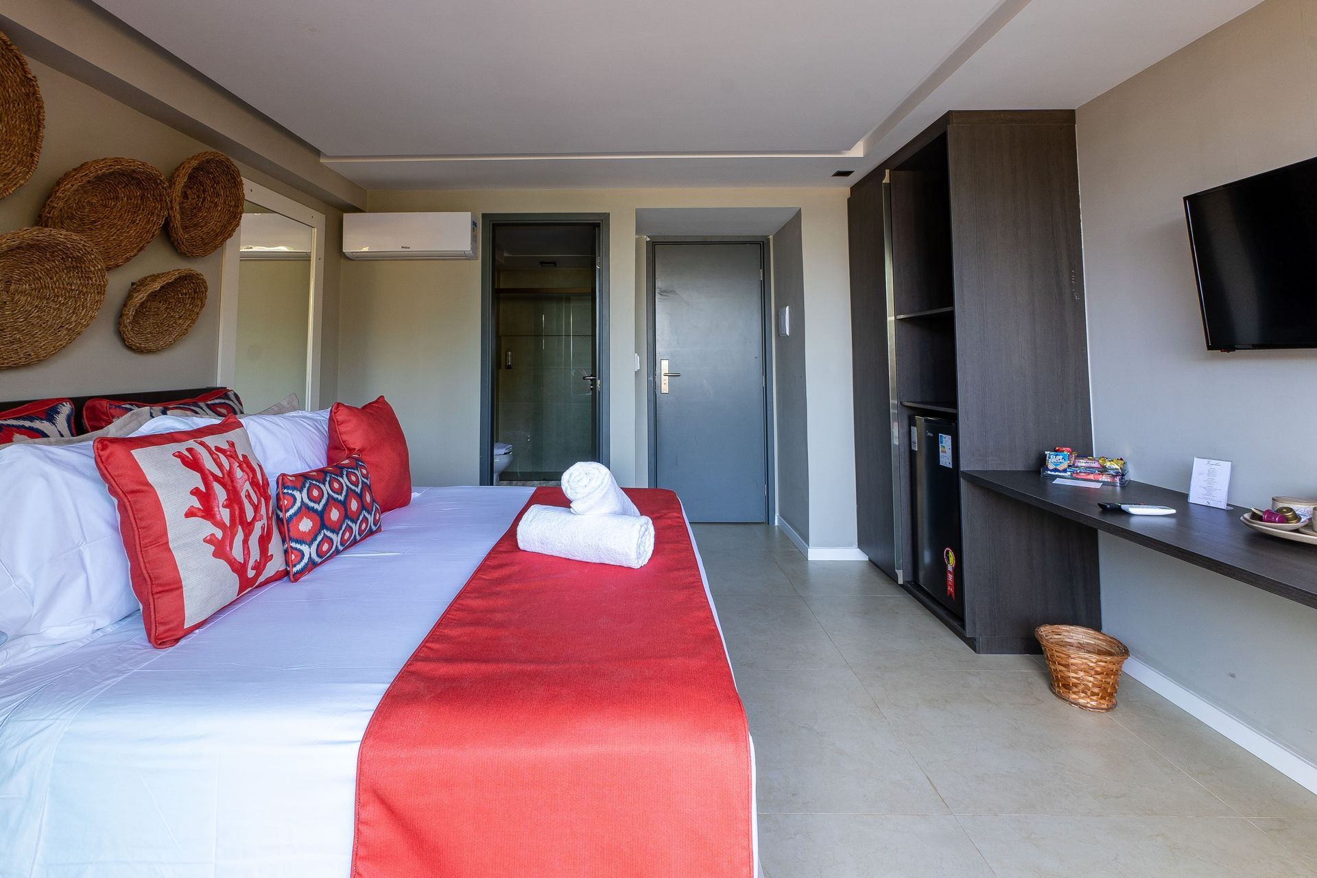 Um quarto de hotel com uma cama grande e uma TV de tela plana.