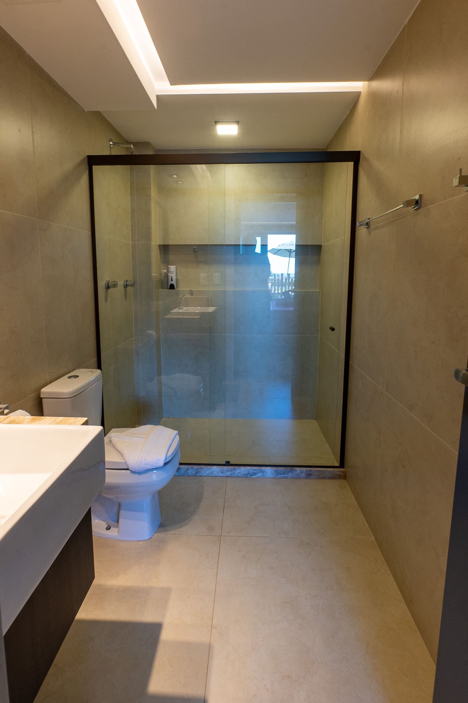 Um banheiro com vaso sanitário, pia e chuveiro.