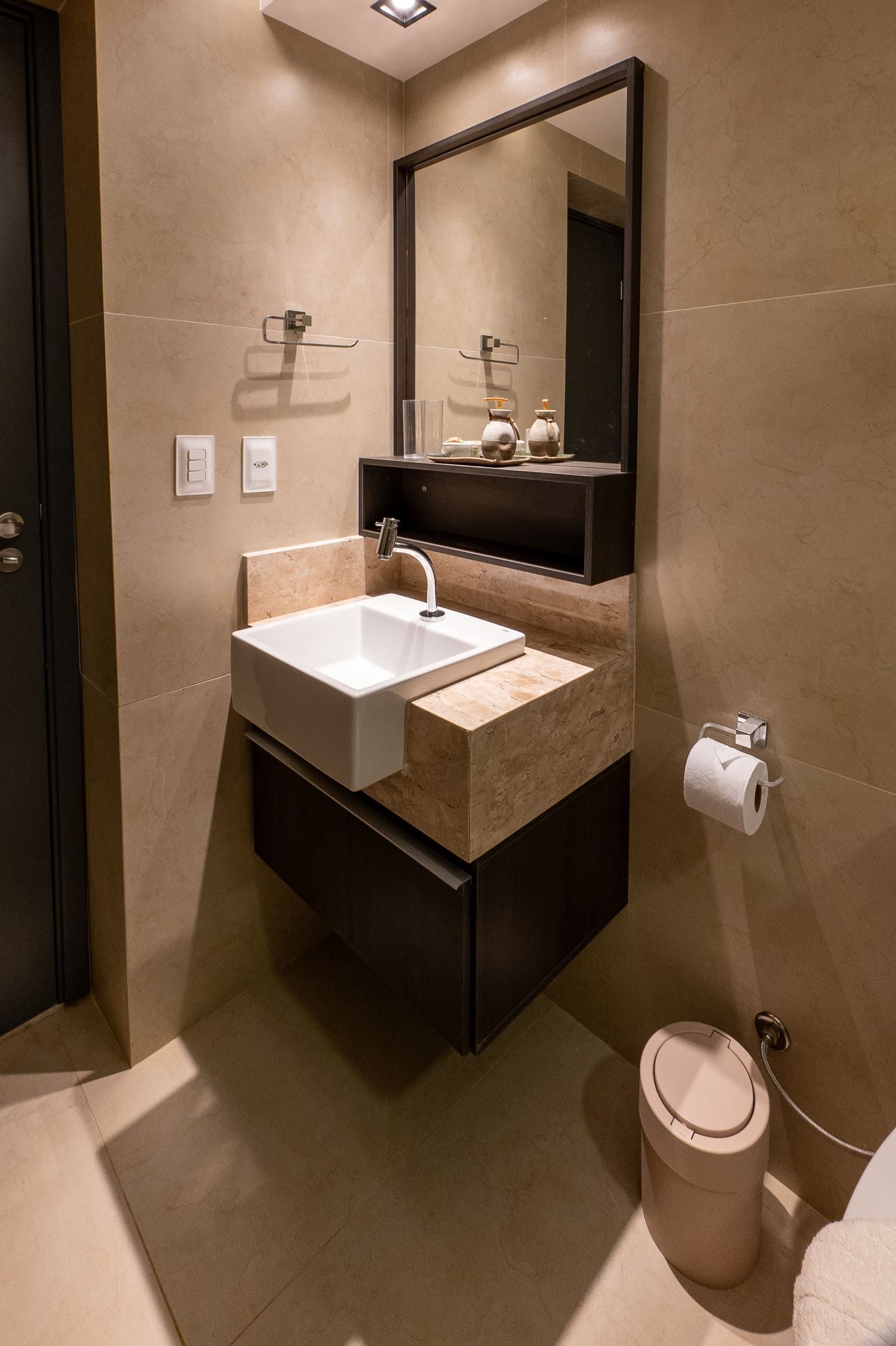 Um banheiro com pia, vaso sanitário e espelho.