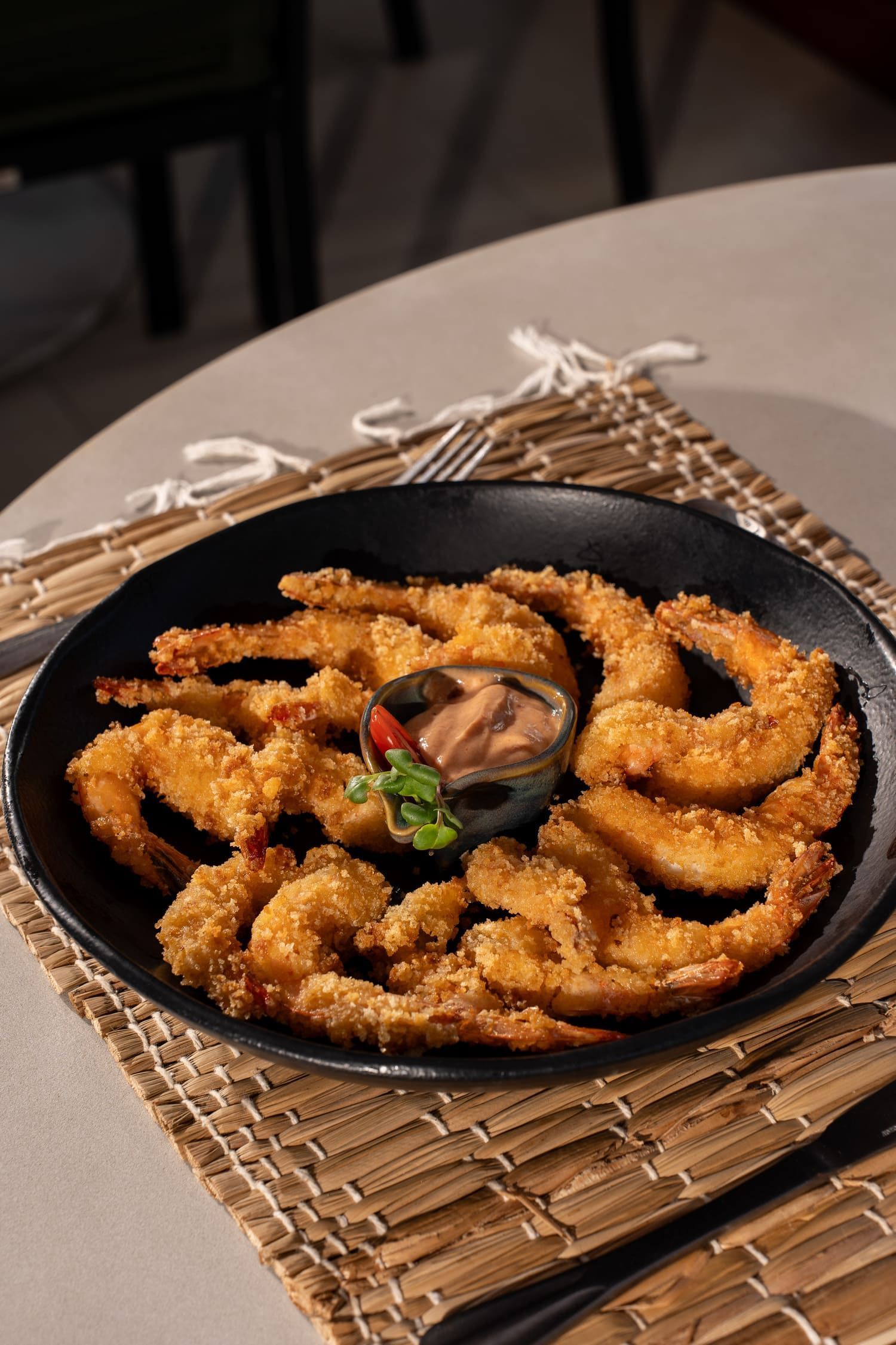 Um prato de camarão frito com molho sobre uma mesa.