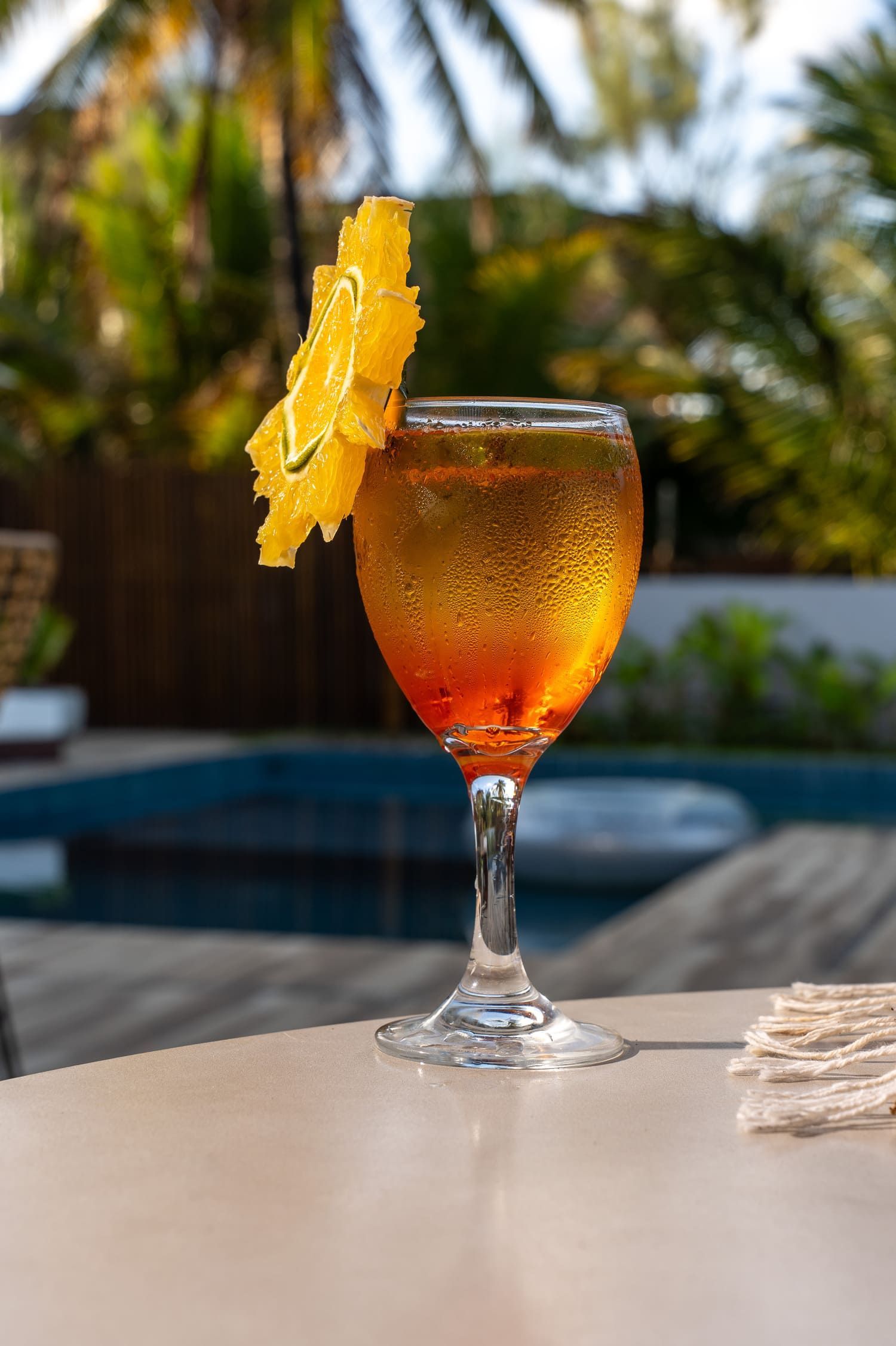 Um close de uma bebida em uma taça de vinho sobre uma mesa.