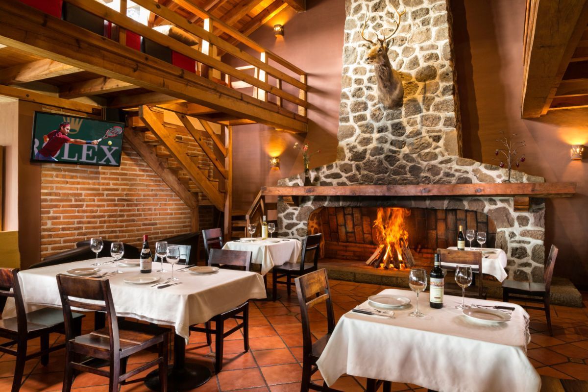 Un restaurante con mesas y sillas y una chimenea.