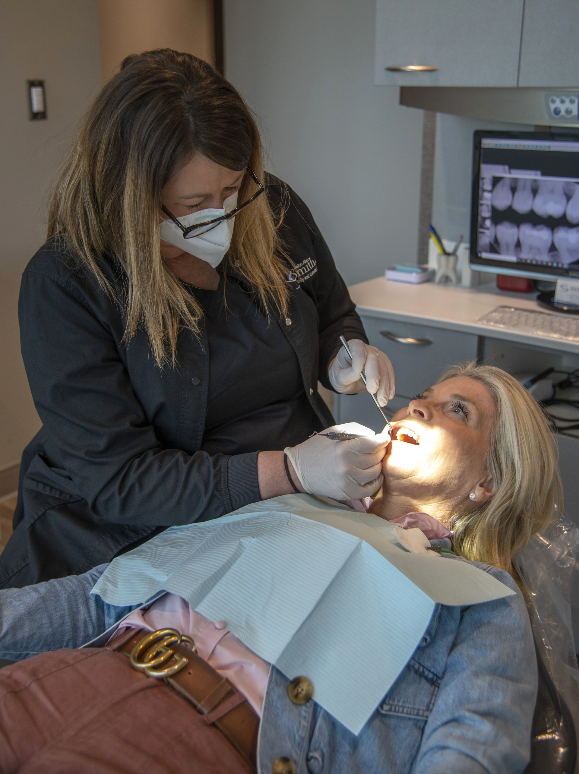 dental assistant examining a patient's teeth