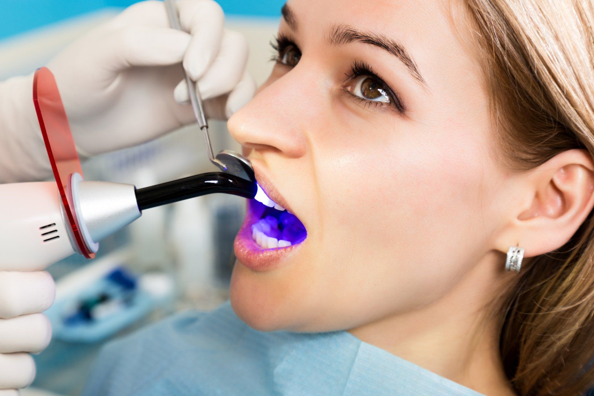 dentist applies uv light to patient's composite filling