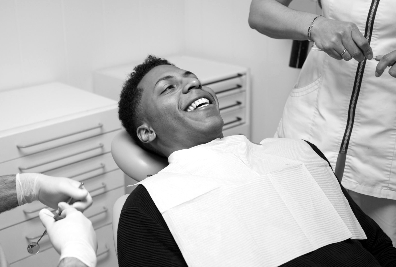man relaxes in exam chair before dental cleaning