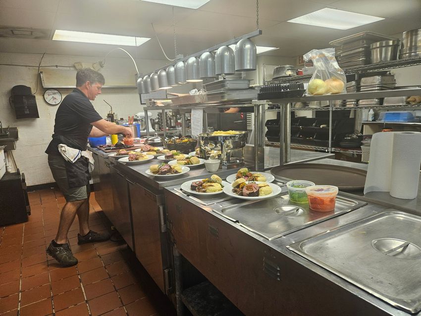 Cozy interior with seating areas, wooden floors, and a view into another room.
