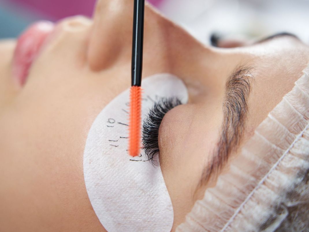 A close up of a woman 's green eye with mascara.