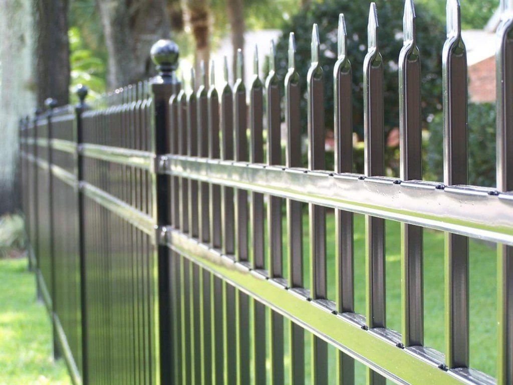 A close up of a metal fence in a yard.