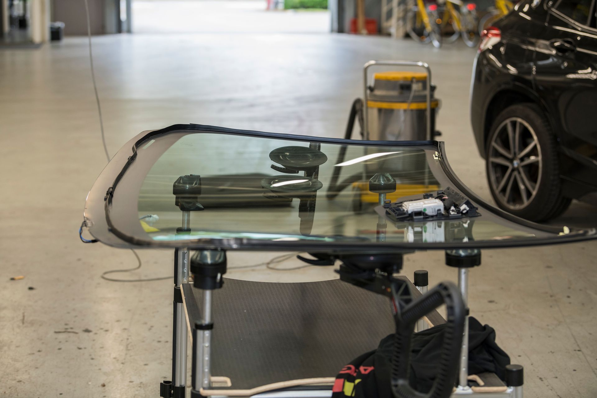 A windshield is being removed from a car in a garage.