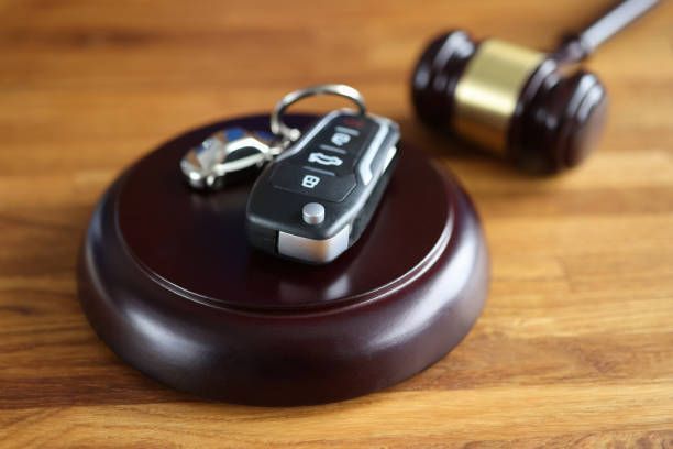 Referee gavel and car remote control on table, symbolizing court involvement in car seizure.