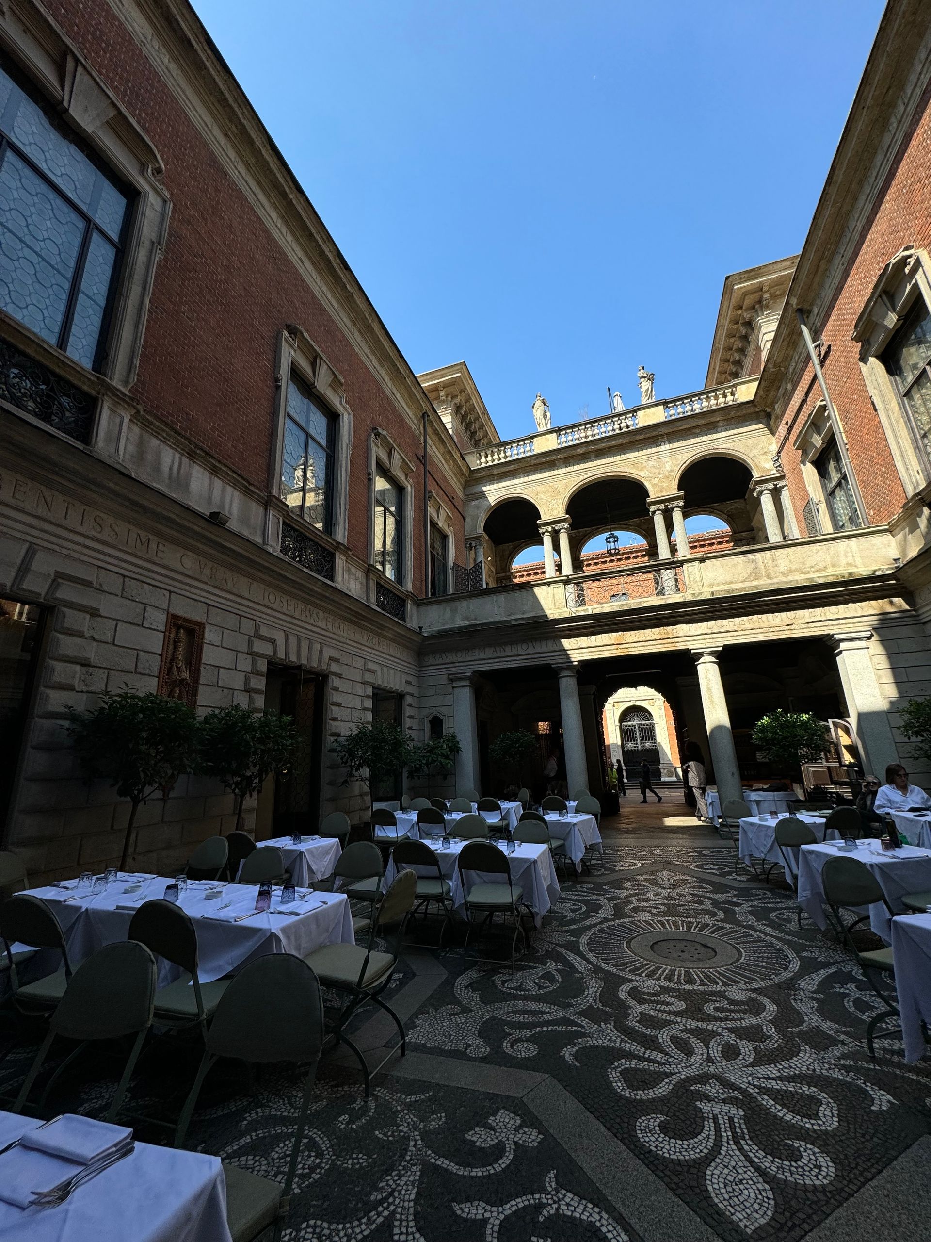 A courtyard with tables and chairs in front of a building