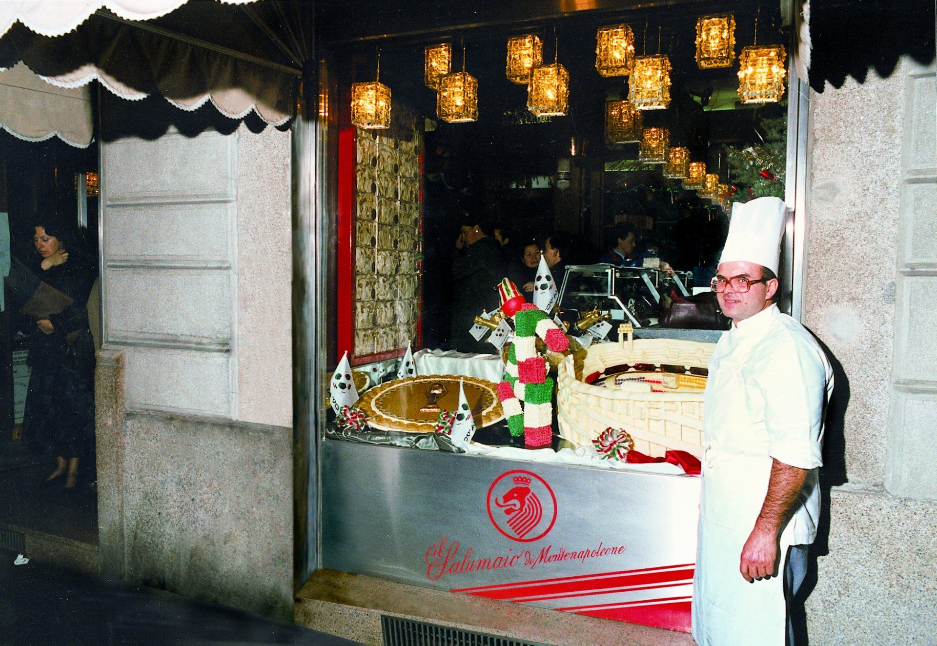 Un uomo con un cappello da chef si trova di fronte a un ristorante