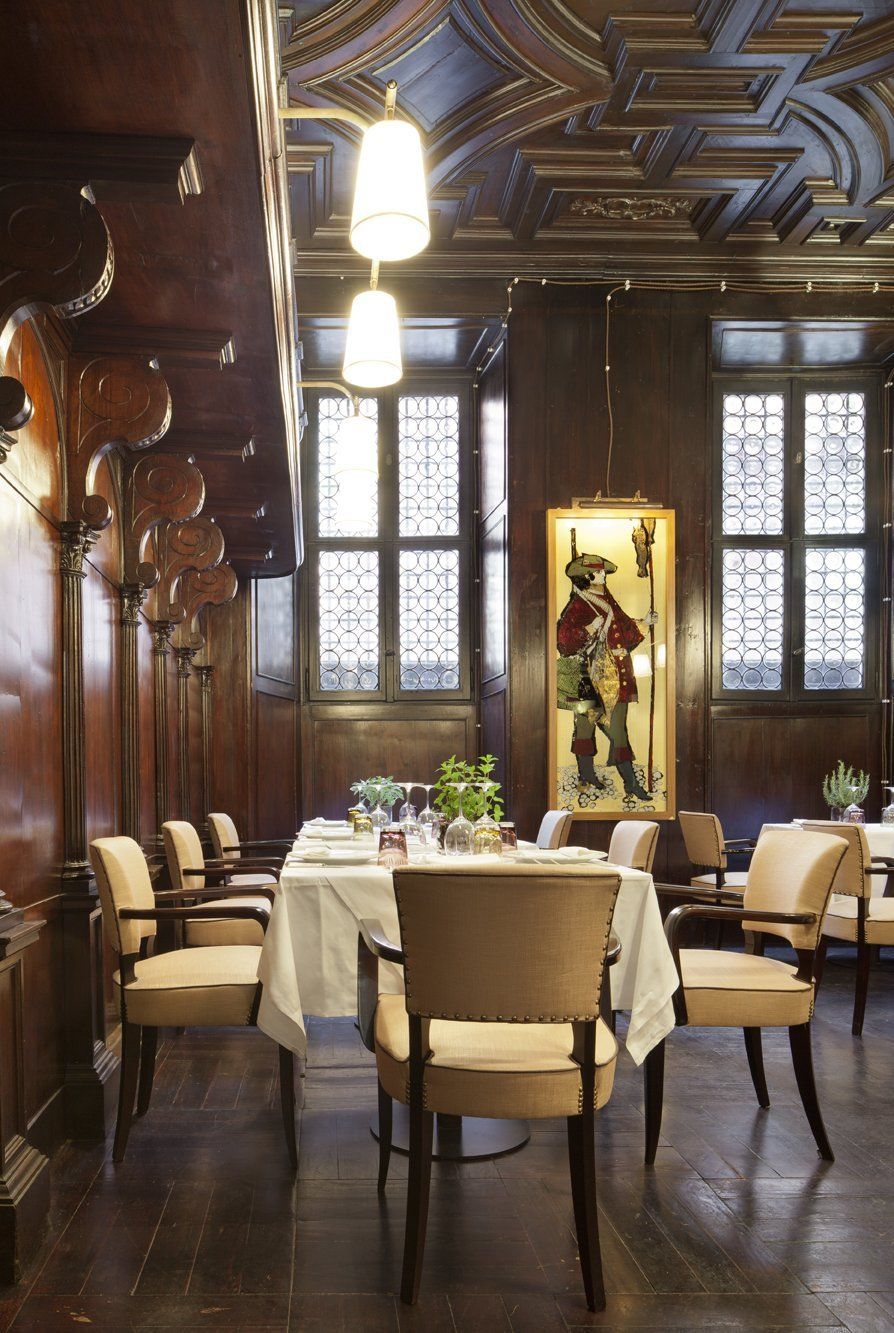 Una sala da pranzo con tavoli e sedie e un quadro alla parete