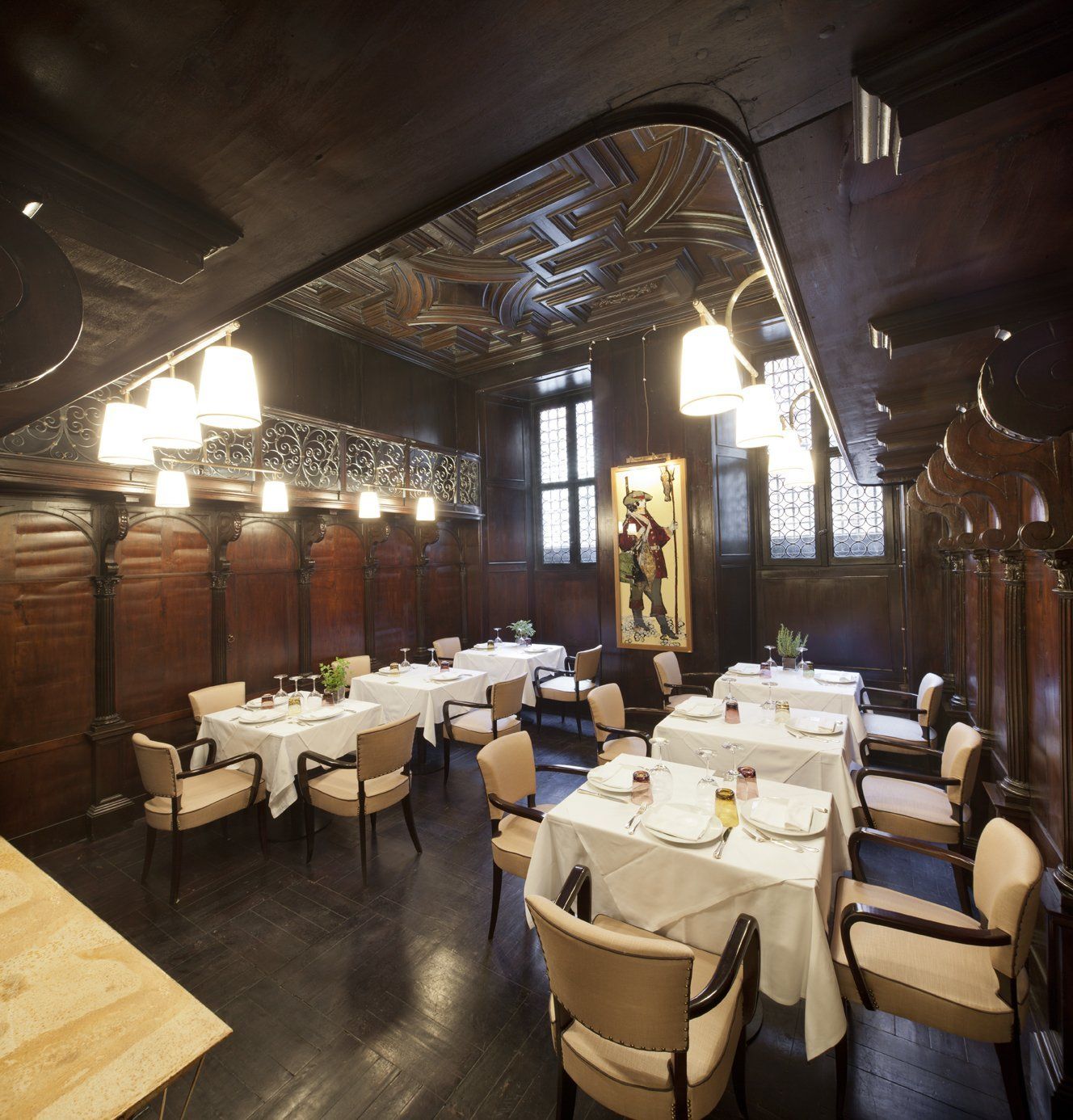 Una sala da pranzo con tavoli e sedie e un quadro alla parete